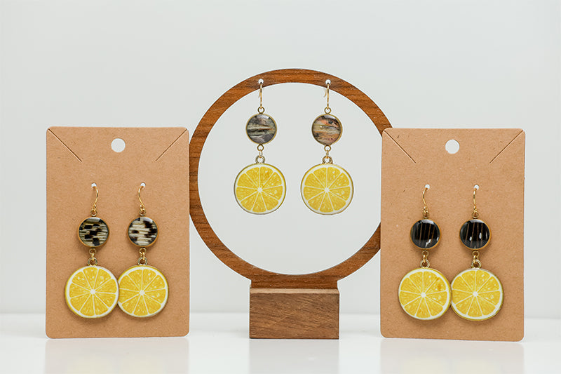 Three pairs of Coastal Capri Earrings on stands on a white background.  