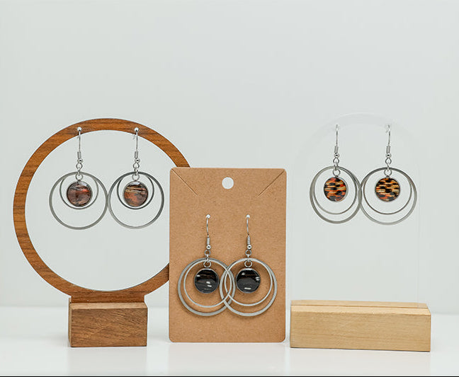 Three pairs of Large Silver Double Loops on stands on a white background. 