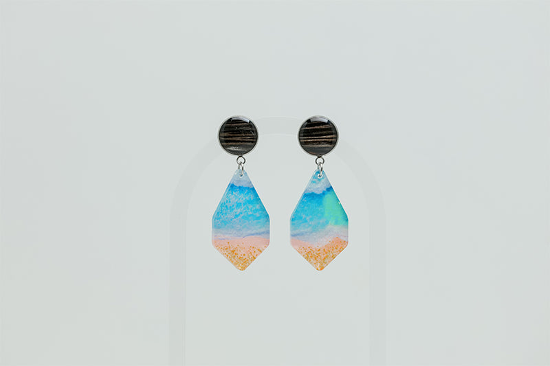 A pair of Seas the Day Earrings on a white background. 