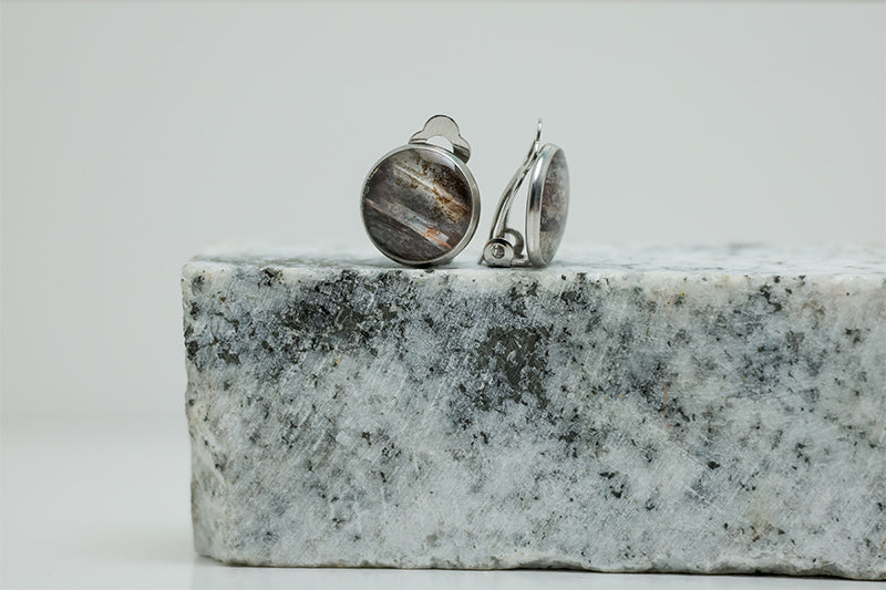 Clip-On Earrings on black and white marble on a white background.