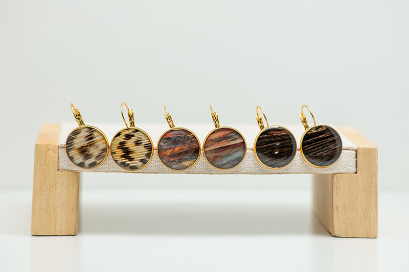 Three pairs of French Hook Earrings on a cream stand on a white background.