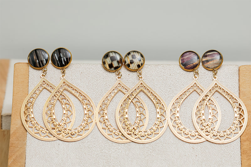 Three pairs of Teardrop Lace Earrings on a cream stand on a white background.