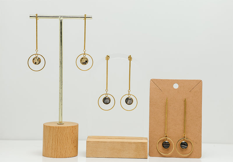 Three pairs of Long Golden Posts on stands on a white background.  