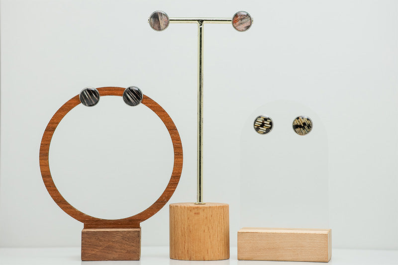 Three pairs of Large Studs on stands on a white background. 