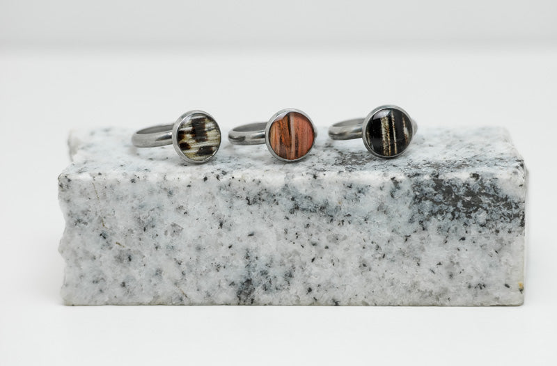 Three Silver Adjustable Rings on black and white marble on a white background.