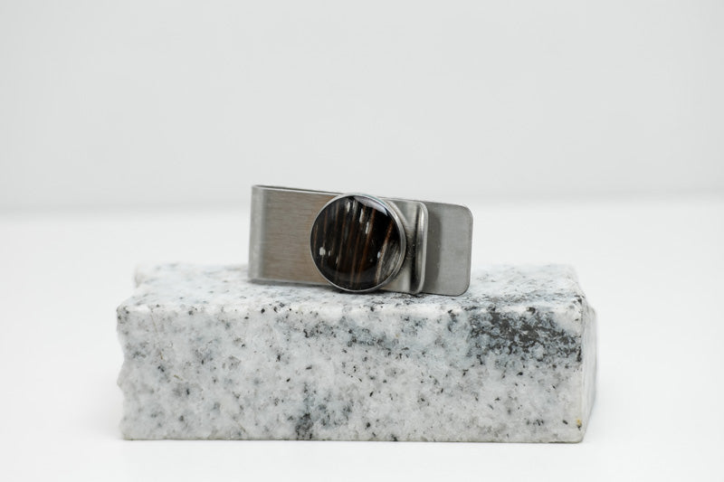 Silver Money Clip on a piece of white and black marble on a white background. 